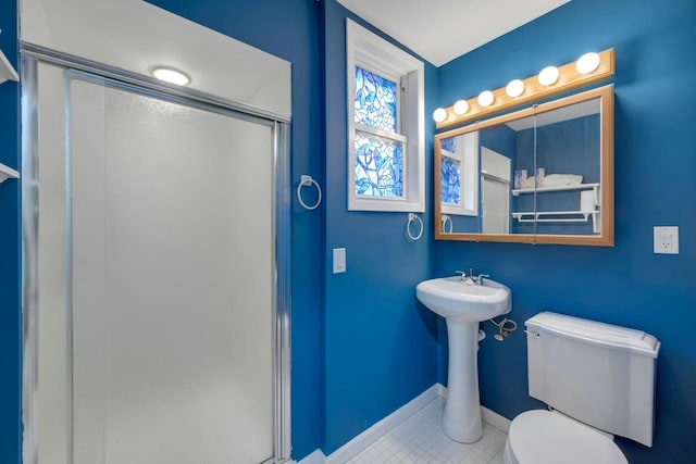 bathroom with tile patterned flooring, toilet, and an enclosed shower