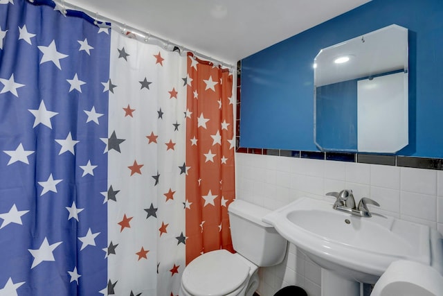 bathroom with toilet, tile walls, and curtained shower