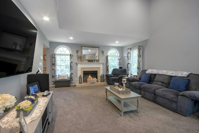 carpeted living room with a lit fireplace and recessed lighting