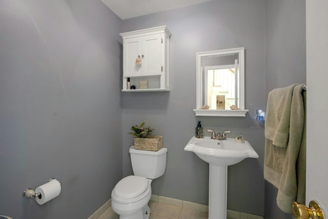 bathroom featuring toilet, tile patterned floors, and baseboards