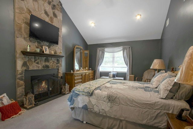 carpeted bedroom with a stone fireplace and high vaulted ceiling
