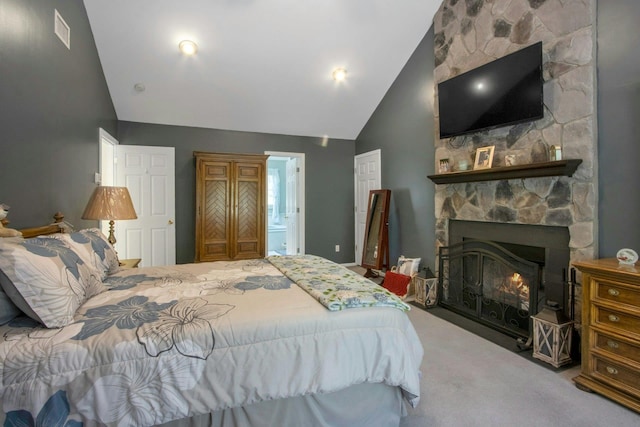 bedroom featuring carpet floors, a stone fireplace, high vaulted ceiling, and ensuite bath