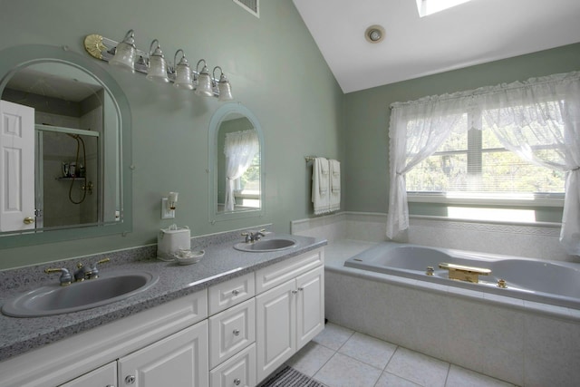 full bath featuring lofted ceiling, tile patterned flooring, a shower stall, a garden tub, and double vanity