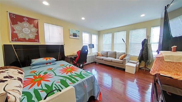 bedroom featuring radiator heating unit and hardwood / wood-style flooring