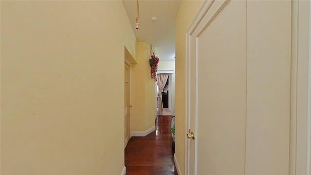 corridor featuring vaulted ceiling and dark wood-type flooring