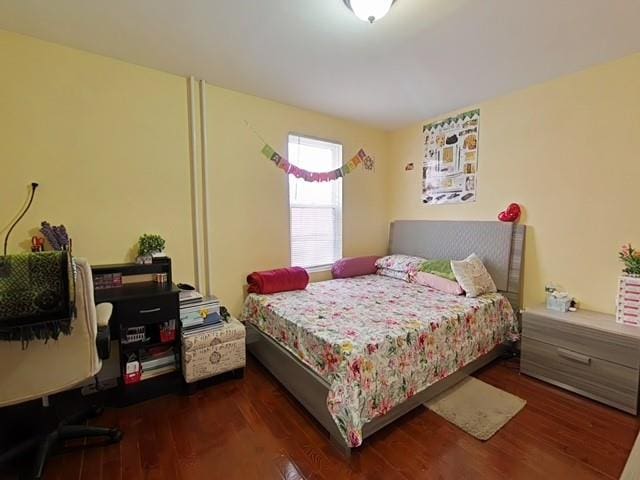 bedroom with dark hardwood / wood-style floors