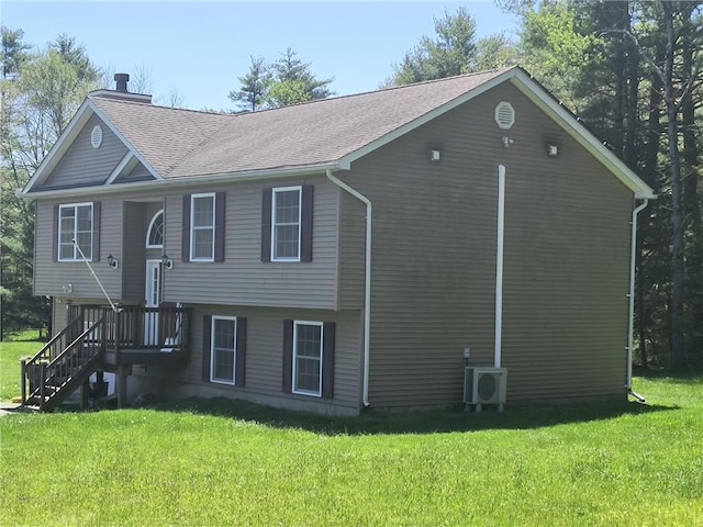 view of front of house featuring ac unit and a front lawn