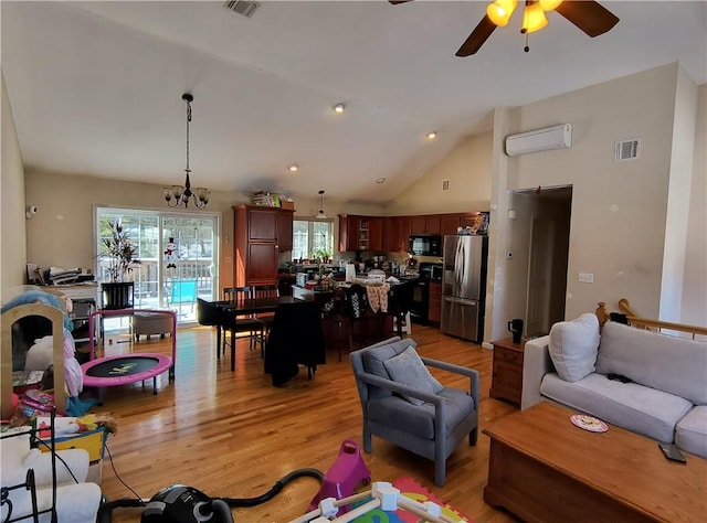 living room featuring a wall mounted air conditioner, high vaulted ceiling, ceiling fan with notable chandelier, and light wood-type flooring