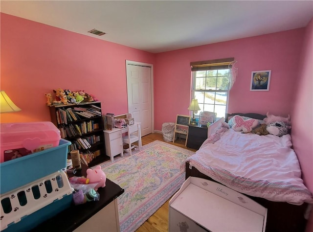 bedroom with light hardwood / wood-style floors and a closet