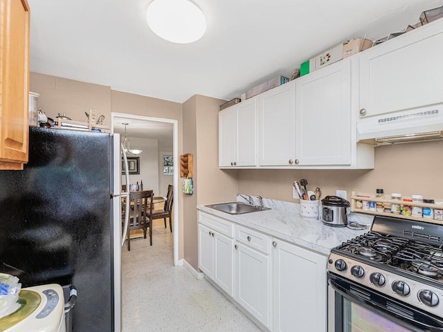 kitchen with white cabinetry, sink, range with gas stovetop, and fridge