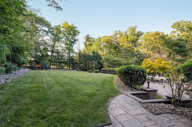 view of yard featuring a playground and a patio area