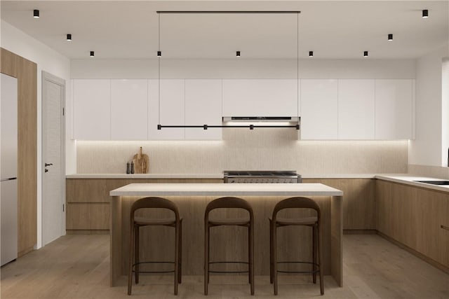 kitchen with white cabinets, light wood-type flooring, and a breakfast bar