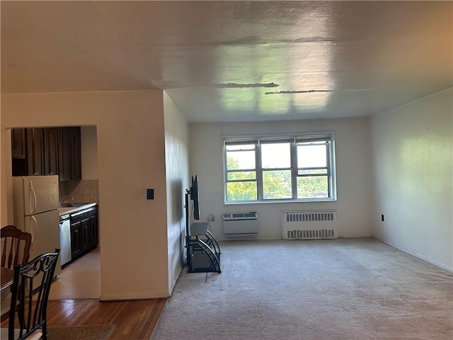 interior space with radiator heating unit, light hardwood / wood-style floors, and sink