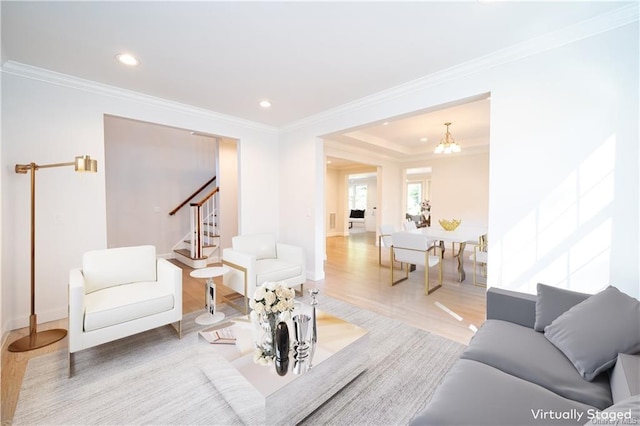 living room featuring crown molding, a chandelier, and hardwood / wood-style flooring