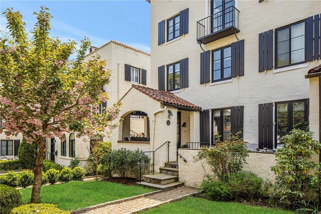 view of front of house featuring stucco siding and a tiled roof