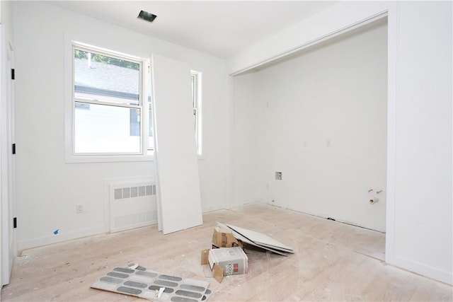 unfurnished room with light hardwood / wood-style floors and radiator