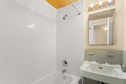 bathroom with shower / bathing tub combination and sink