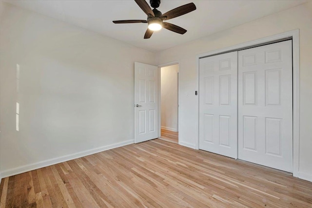 unfurnished bedroom featuring ceiling fan, a closet, and light wood-type flooring