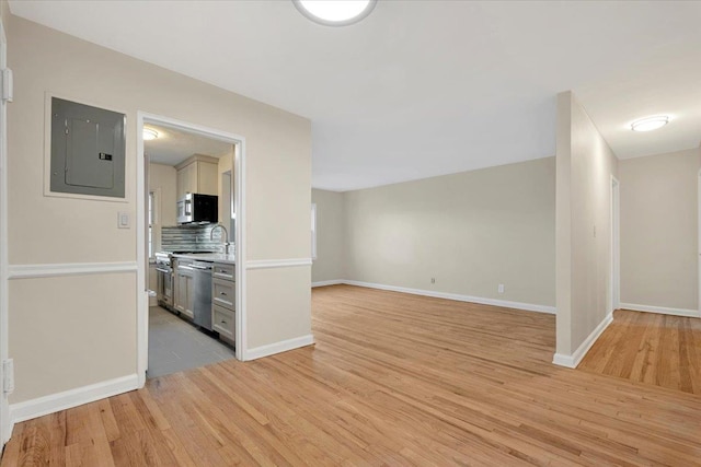 unfurnished living room featuring electric panel and light wood-type flooring