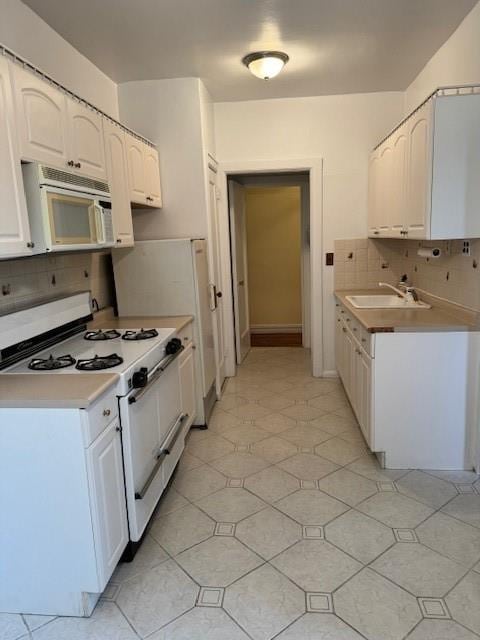 kitchen with white cabinets, white appliances, tasteful backsplash, and sink