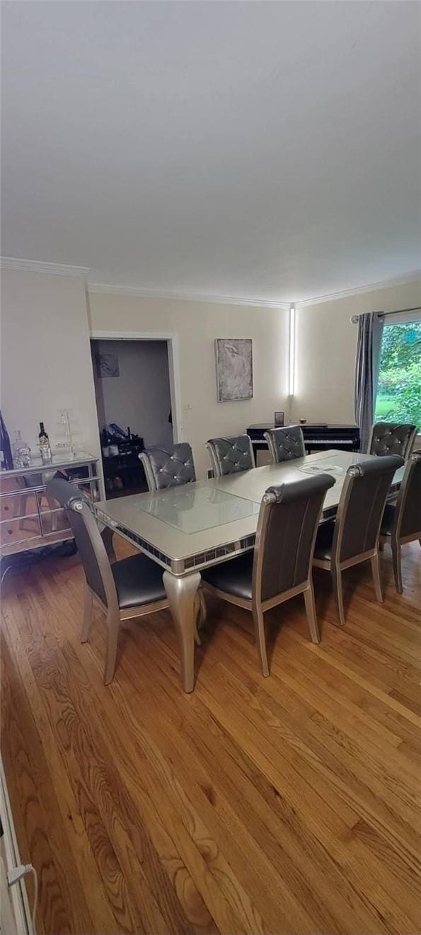 dining area featuring crown molding and hardwood / wood-style floors