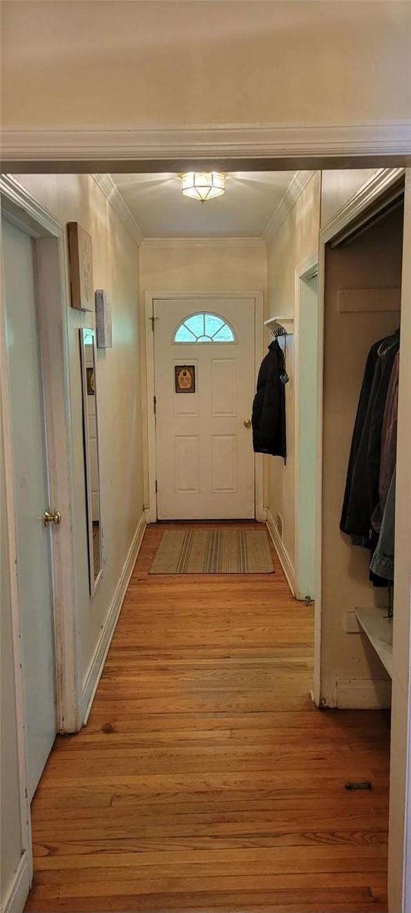 entryway featuring light wood-type flooring and ornamental molding