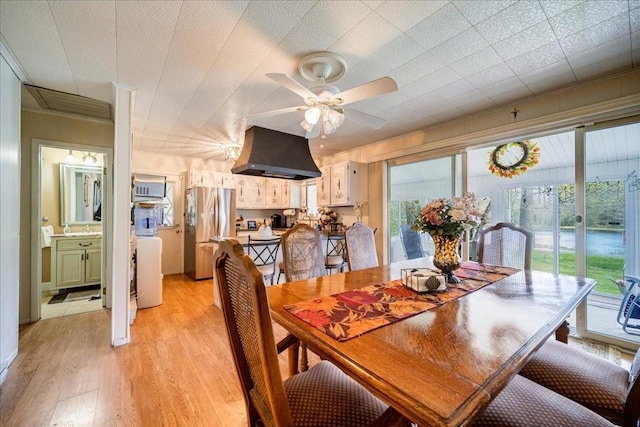 dining space featuring ceiling fan, light wood-type flooring, and sink