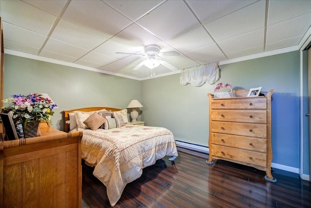 bedroom featuring a paneled ceiling, dark hardwood / wood-style floors, baseboard heating, and ceiling fan