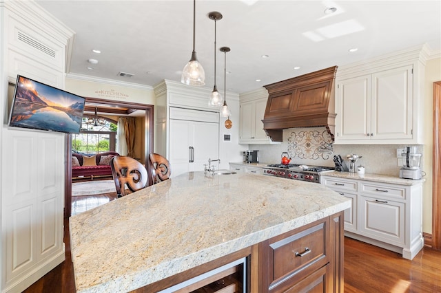 33 Livingston Ave, Dobbs Ferry, NY 10522 - kitchen with custom range hood, a sink, light stone countertops, decorative backsplash, and white cabinetry