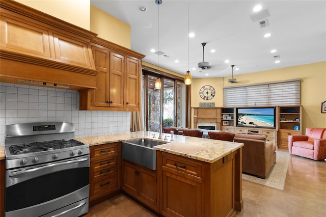 33 Livingston Ave, Dobbs Ferry, NY 10522 - kitchen featuring stainless steel gas range oven, a sink, a fireplace, brown cabinetry, and a peninsula
