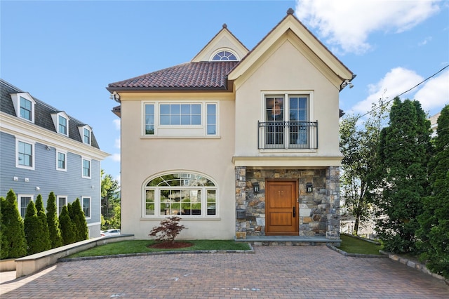 33 Livingston Ave, Dobbs Ferry, NY 10522 - view of front of property featuring a balcony, stucco siding, stone siding, and a tile roof