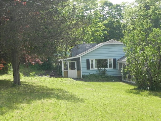 view of home's exterior featuring a yard and a sunroom