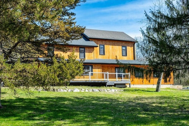 rear view of property with a lawn and a deck