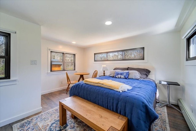 bedroom with wood-type flooring and a baseboard radiator