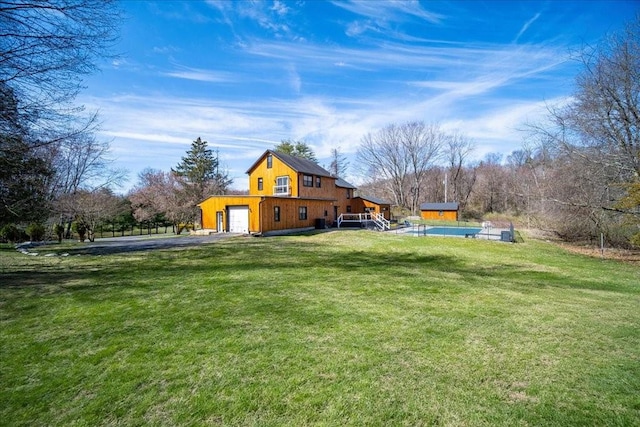 view of yard with a pool and a garage