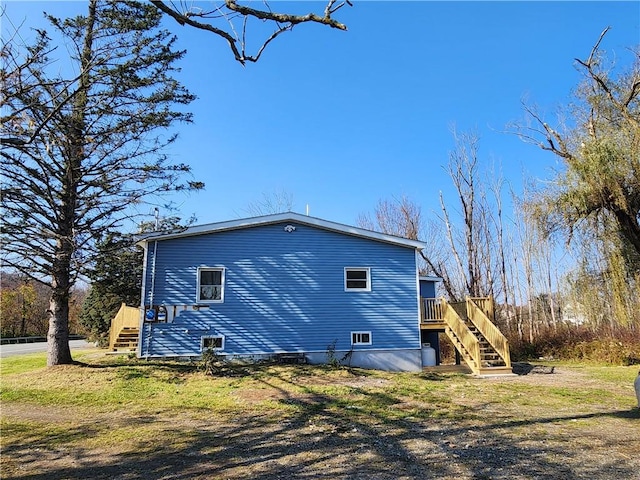 view of side of property featuring a wooden deck and a yard