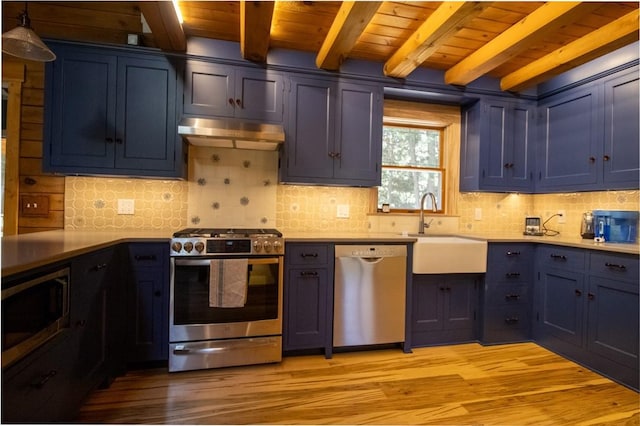 kitchen featuring pendant lighting, blue cabinets, sink, light wood-type flooring, and appliances with stainless steel finishes