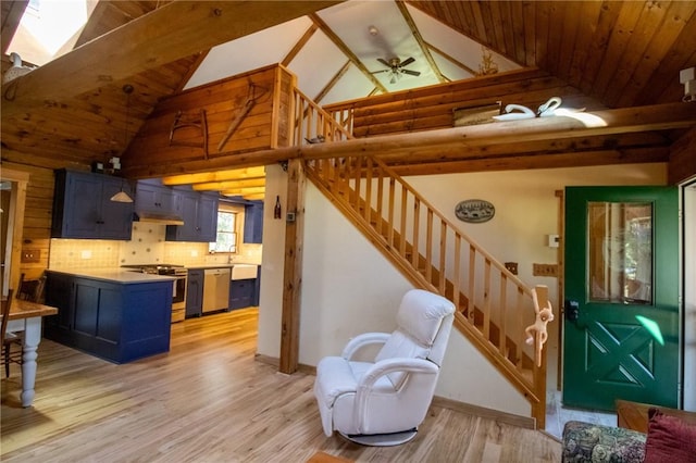 living room featuring beam ceiling, light hardwood / wood-style floors, ceiling fan, and wooden ceiling