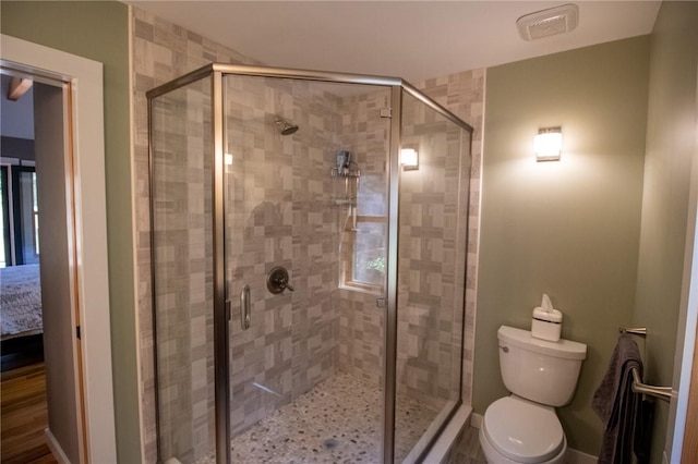 bathroom featuring toilet and a shower with door