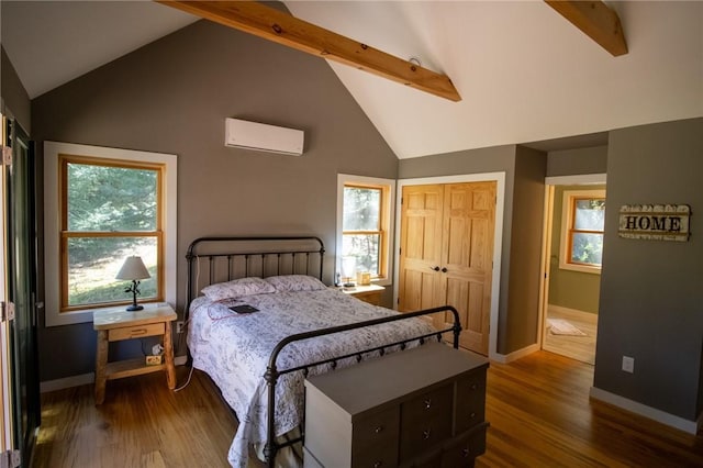 bedroom with a wall mounted AC, a closet, hardwood / wood-style floors, and beamed ceiling