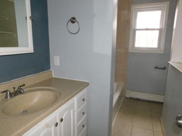 bathroom with tile patterned flooring, vanity, and a baseboard heating unit