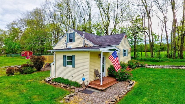 view of front facade with a deck and a front lawn