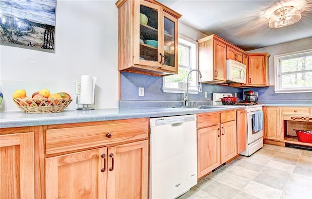 kitchen with decorative backsplash, white appliances, and sink