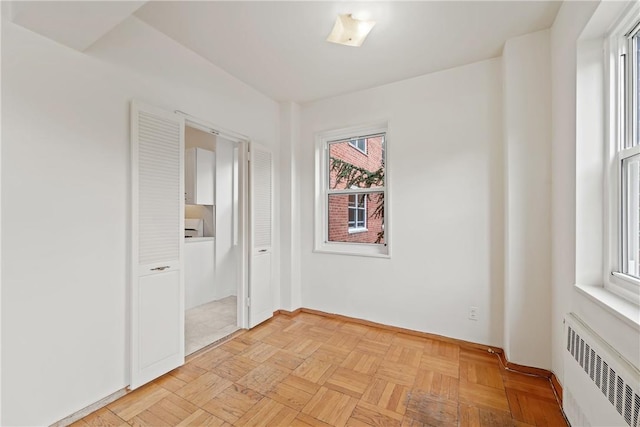 empty room featuring light parquet floors and radiator