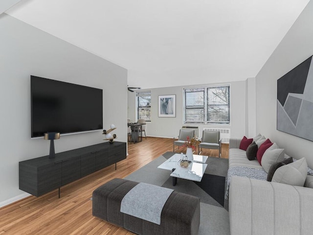 living room featuring light hardwood / wood-style floors and vaulted ceiling