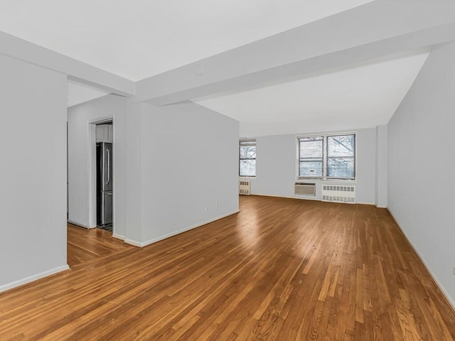 unfurnished living room with radiator and wood-type flooring