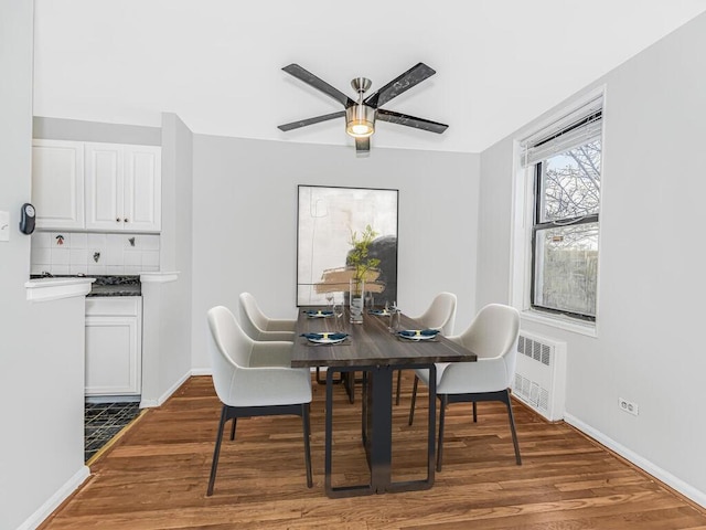 dining area with hardwood / wood-style flooring, radiator, and ceiling fan