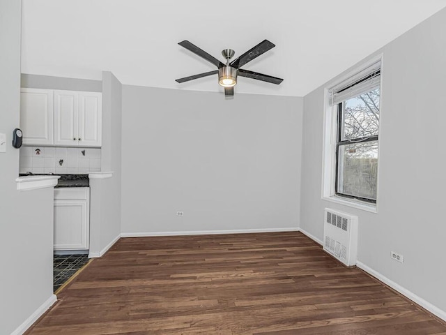 interior space with radiator, ceiling fan, and dark wood-type flooring