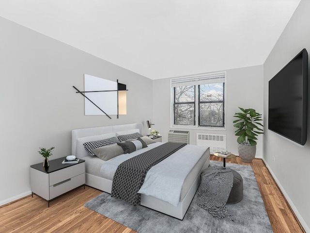 bedroom with hardwood / wood-style floors and radiator heating unit