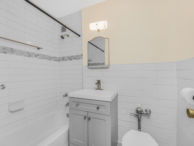 full bathroom featuring tiled shower / bath, vanity, toilet, and tile walls